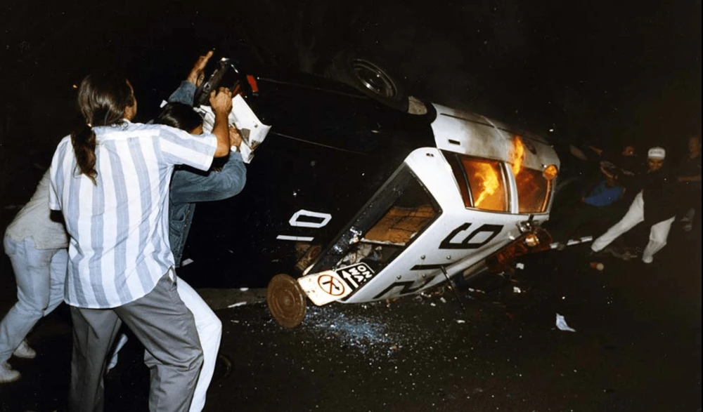 Una macchina della polizia è incendiata e rovesciata dai manifestanti. (Los Angeles Times)