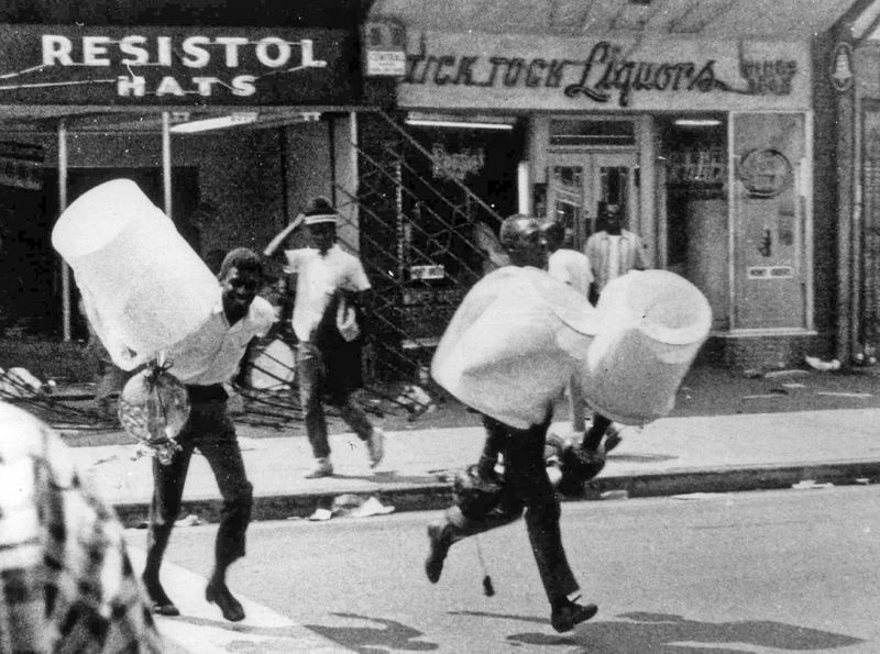 Manifestanti escono dai negozi assaltati durante le proteste, 13 Agosto 1965. (AP Photo)