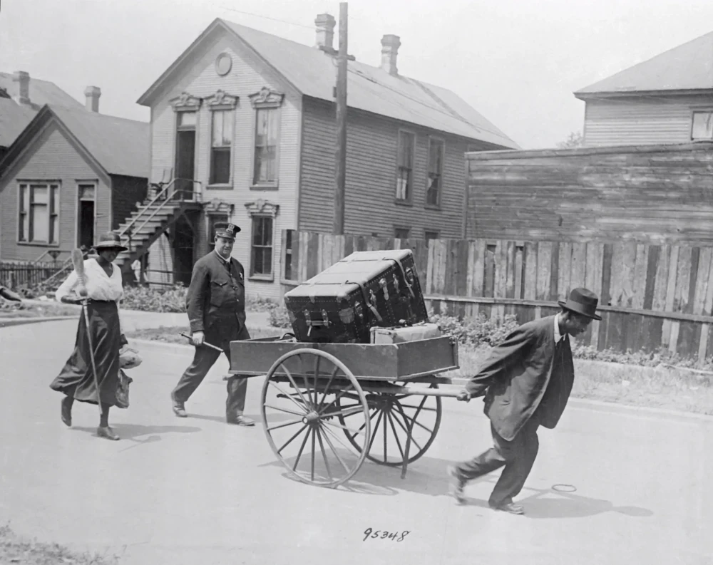 Un poliziotto scorta due afro-americani che abbandonano la loro casa dopo la rivolta. 1919. (Chicago History Museum)
