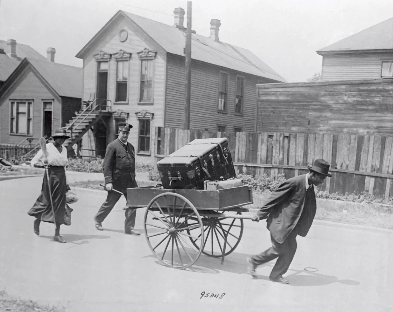 Un poliziotto scorta due afro-americani che abbandonano la loro casa dopo la rivolta. 1919. (Chicago History Museum)